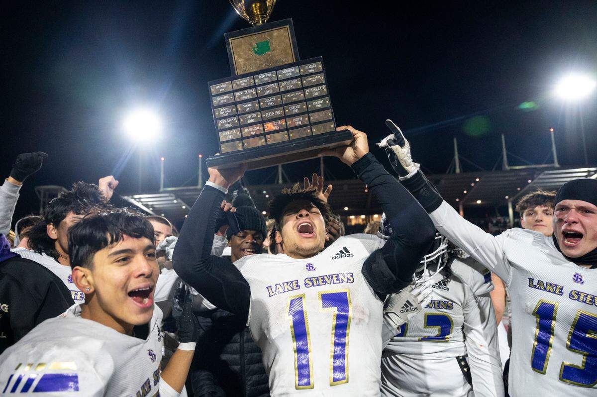 Lake Stevens’ Jayden Limar hoists the championship trophy after the Vikings beat Kennedy Catholic, 24-22, in the Class 4A state title game on Saturday, Dec. 3, 2022, at Mount Tahoma High School in Tacoma, Wash.