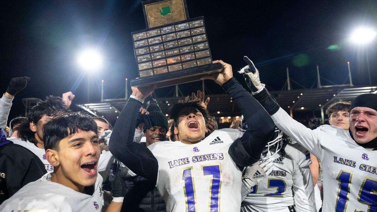 Lake Stevens’ Jayden Limar hoists the championship trophy after the Vikings beat Kennedy Catholic, 24-22, in the Class 4A state title game on Saturday, Dec. 3, 2022, at Mount Tahoma High School in Tacoma, Wash.