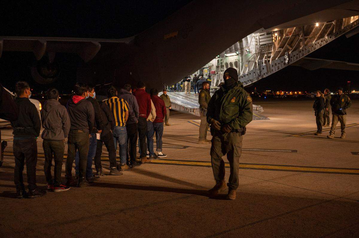 U.S. Customs and Border Protection Agents guide deportees onboard a C-17 Globemaster III at the Tucson International Airport, Ariz., Jan. 23, 2025. Under the direction of U.S. Northern Command, U.S. Transportation Command is supporting Immigration and Customs Enforcement removal flights by providing military airlift. (Dept. of Defense photo by Senior Airman Devlin Bishop)