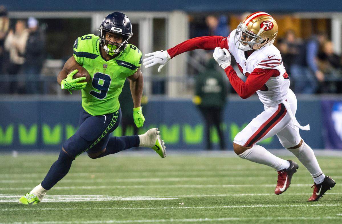 Seattle Seahawks running back Kenneth Walker III (9) runs down the field with the ball as San Francisco 49ers cornerback Deommodore Lenoir (38) tries to guard him in the fourth quarter of an NFL game at Lumen Field in Seattle Wash. on Dec. 15, 2022.