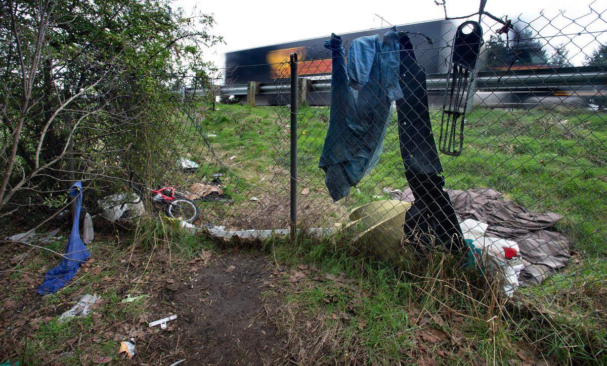 Trash lines a trail to a homeless encampment along Interstate 5 through Tacoma, Washington, on Wednesday, Feb. 17, 2021.