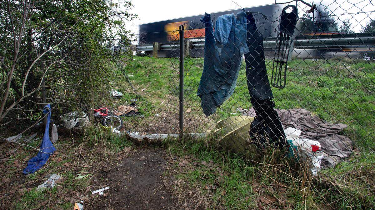 Trash lines a trail to a homeless encampment along Interstate 5 through Tacoma.