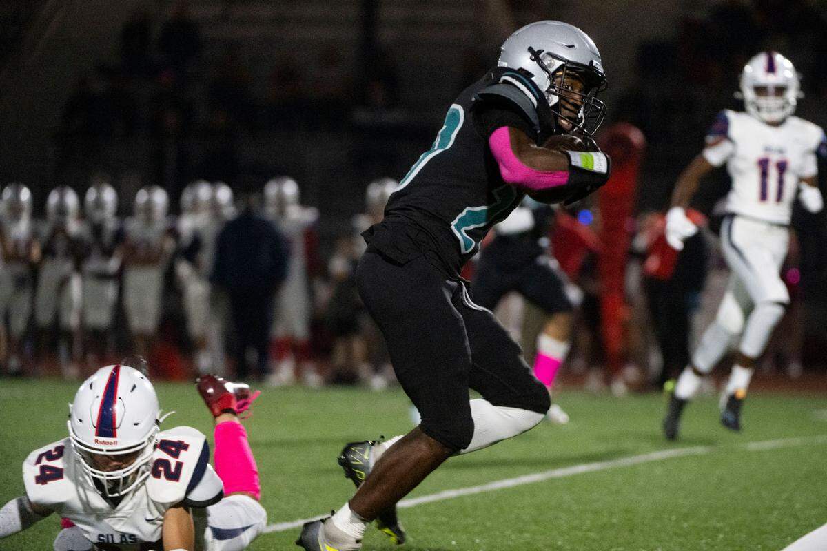 Spanaway Lake running back D’Aryhian Clemons skips past a tackle attempt by Silas’ Logan Walker during the first quarter of a 3A PCL game on Friday, Oct. 7, 2022, at Art Crate Field in Spanaway, Wash.