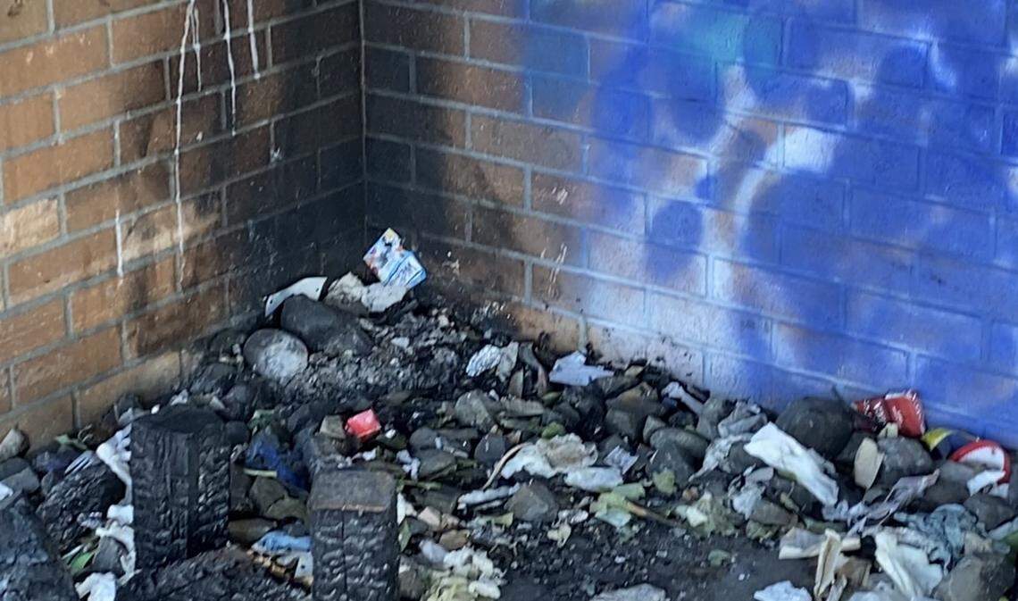 A corner of the exterior of the former Amtrak station at 1001 Puyallup Ave. in Tacoma is filled with trash, fire scars and graffiti.