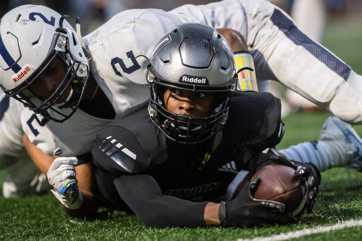 UnionÌs Tobias Merriweather looks up from a tackle to see that he completed a first down, effectively winning the Titans battle with the Riverhawks 21-20 at McKenzie Stadium on Friday night, Sept 27, 2019. (Nathan Howard/The Columbian)