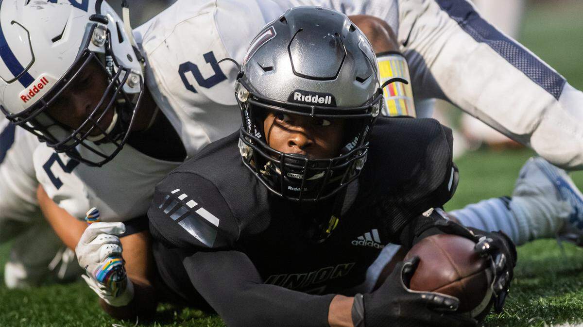 UnionÌs Tobias Merriweather looks up from a tackle to see that he completed a first down, effectively winning the Titans battle with the Riverhawks 21-20 at McKenzie Stadium on Friday night, Sept 27, 2019. (Nathan Howard/The Columbian)