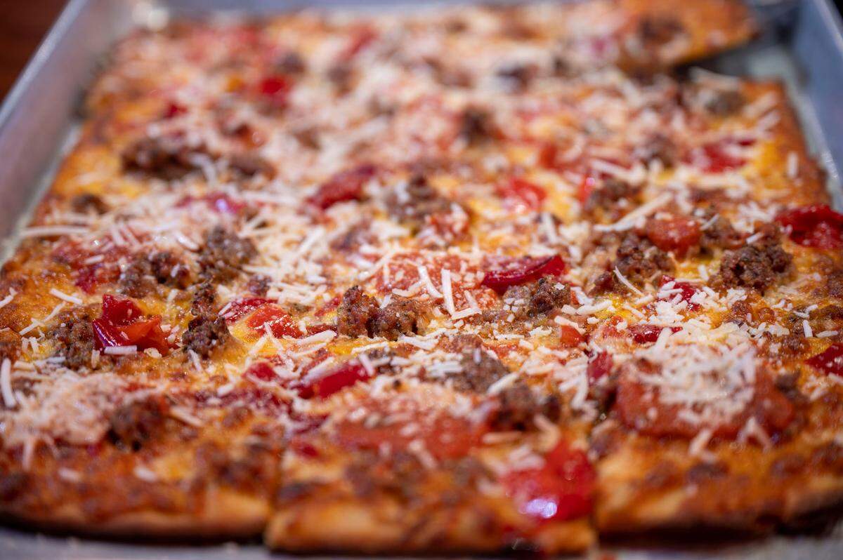 The Haven at E9 Firehouse & Gastropub features Italian sausage, sweet peppers, roast red sauce, a blend of mozzarella and Tillamook cheddar cheese, dusted with Romano to finish.
