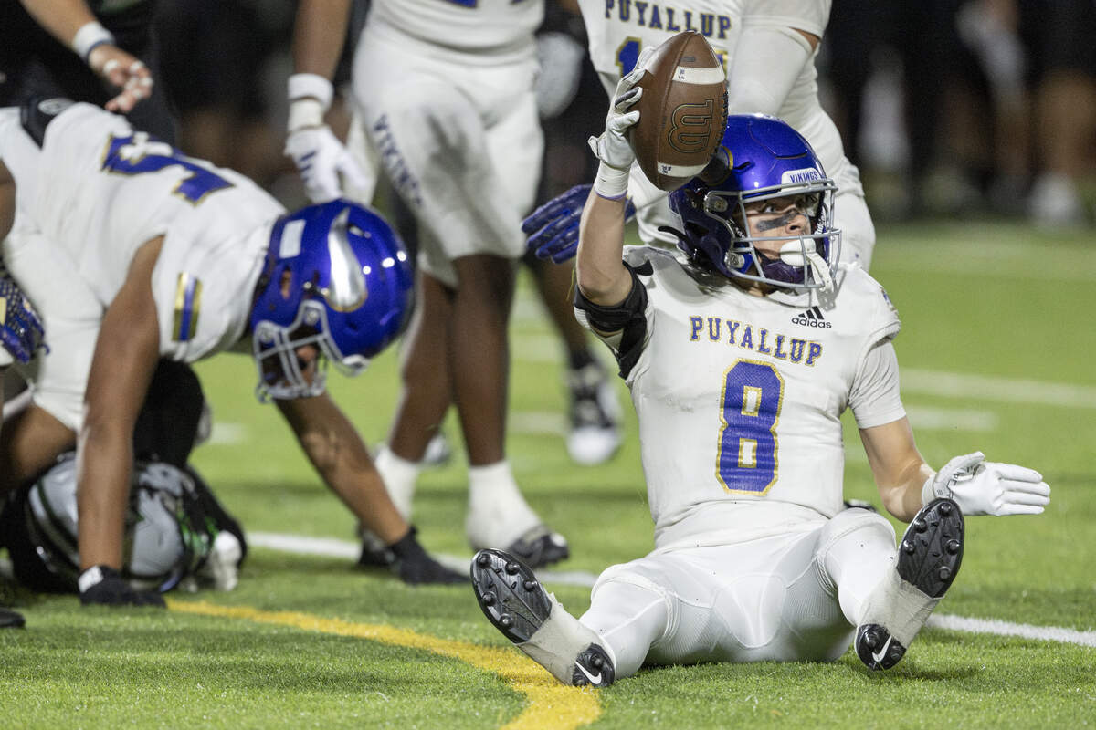 Puyallup’s Cody McFadden (8) raises the ball after a tackle took control of the ball away from Emerald Ridge on Friday, Sept. 26, 2025, in Puyallup, Wash.