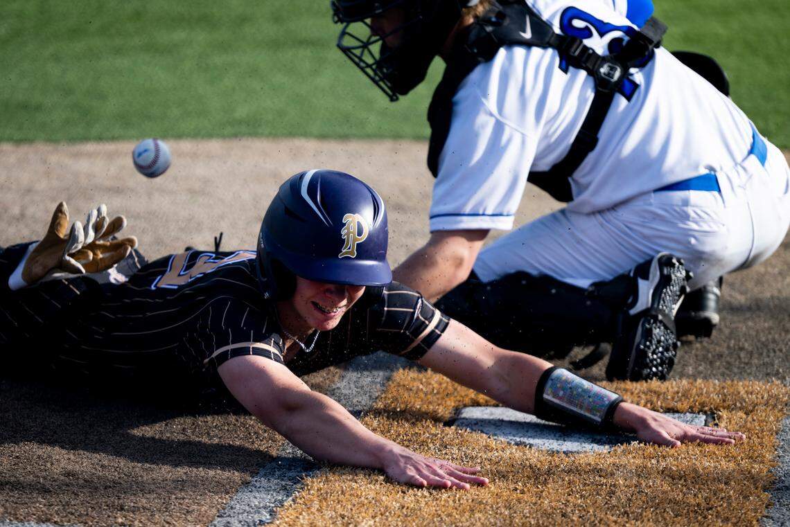 Puyallup’s DJ Ringenbach (13) slides into home plate to score a run against Curtis’s Joe Giles (13) during the baseball game at Curtis Senior High School, on Tuesday, April 15, 2025, in University Place, Wash.
