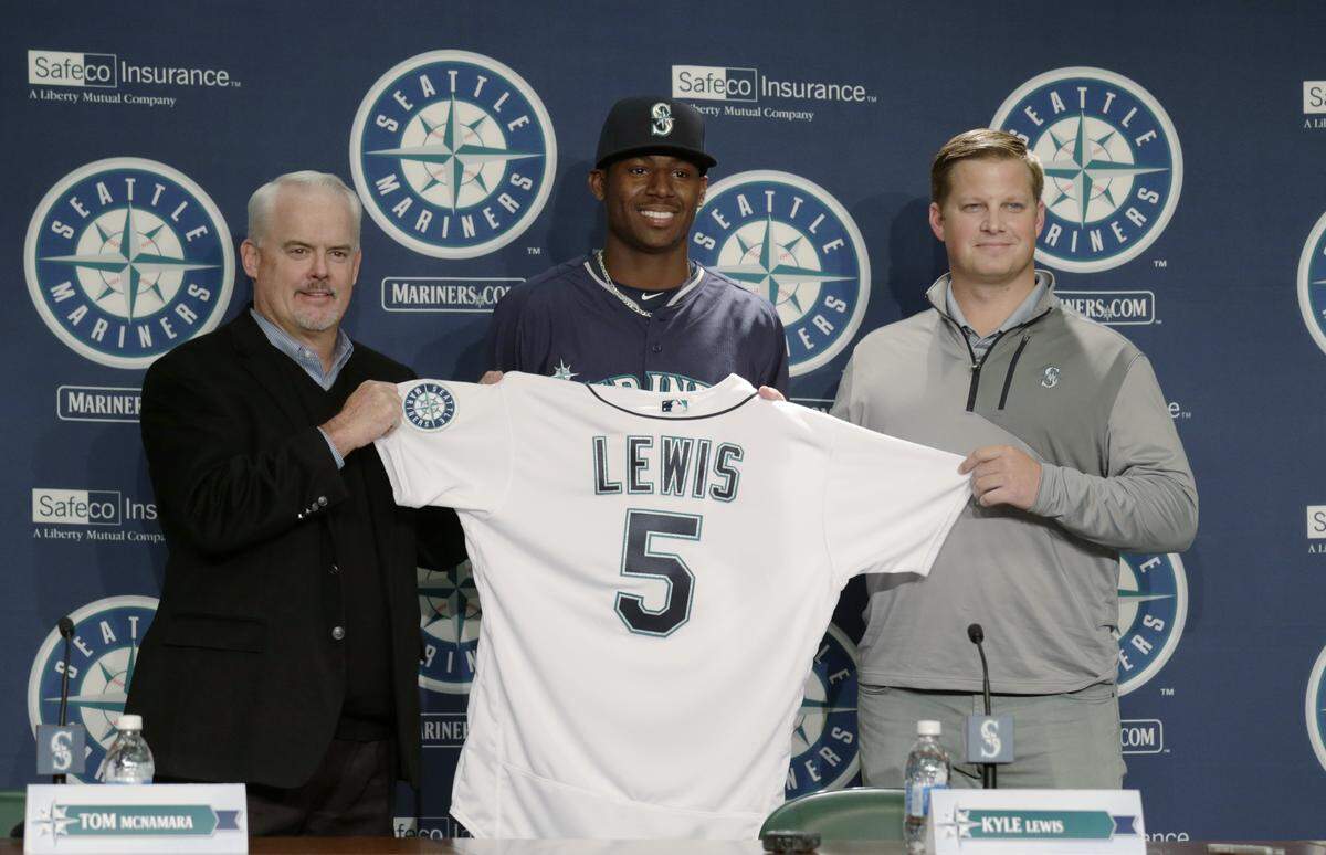 Seattle Mariners first-round draft pick Kyle Lewis holds up his jersey with Tom McNamara, director of amateur scouting, left, and scout John Wiedenbauer, right, during a news conference Saturday, June 11, 2016, in Seattle. (AP Photo/John Froschauer)