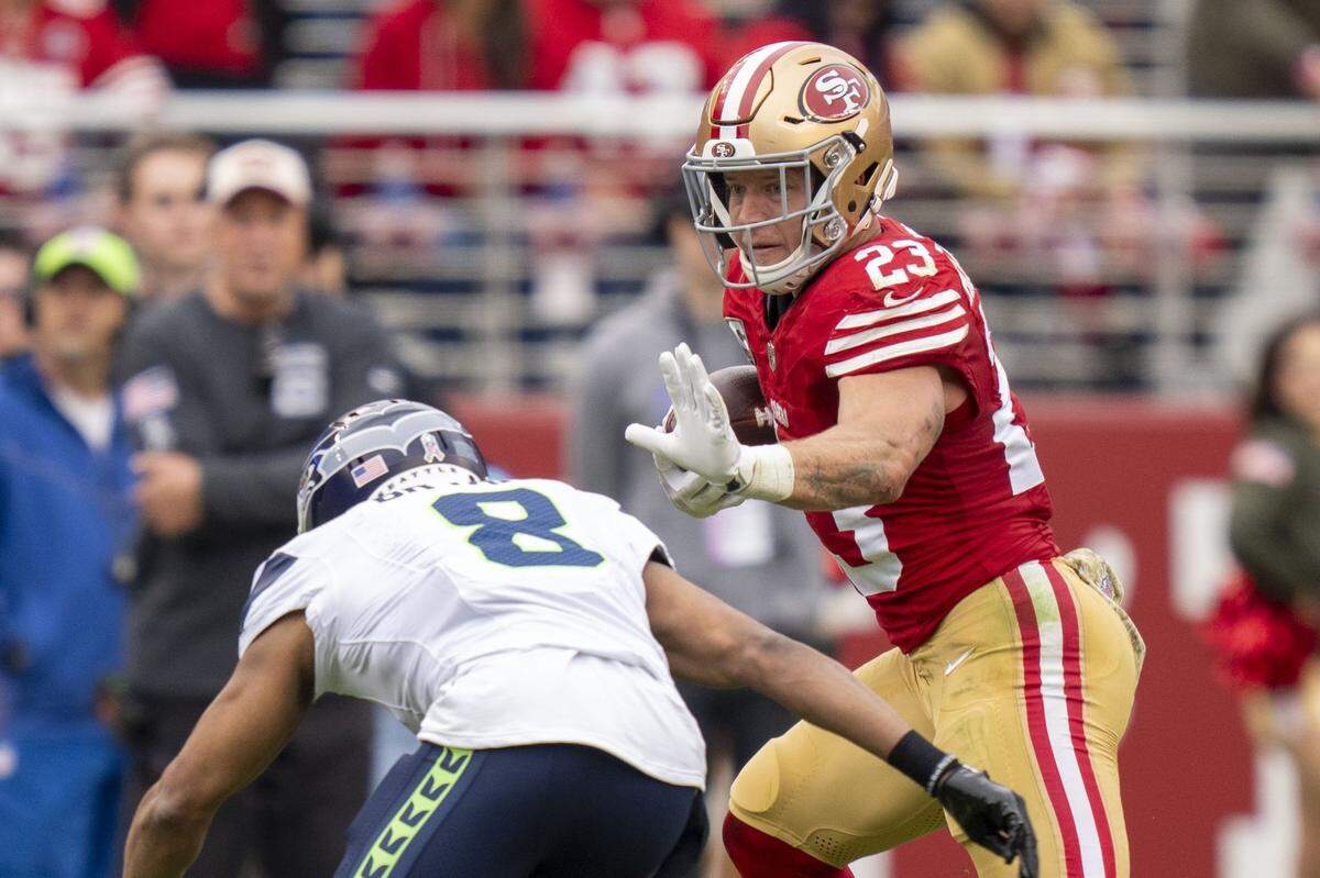 November 17, 2024; Santa Clara, California, USA; San Francisco 49ers running back Christian McCaffrey (23) runs against Seattle Seahawks cornerback Coby Bryant (8) during the second quarter at Levi's Stadium. Mandatory Credit: Kyle Terada-Imagn Images