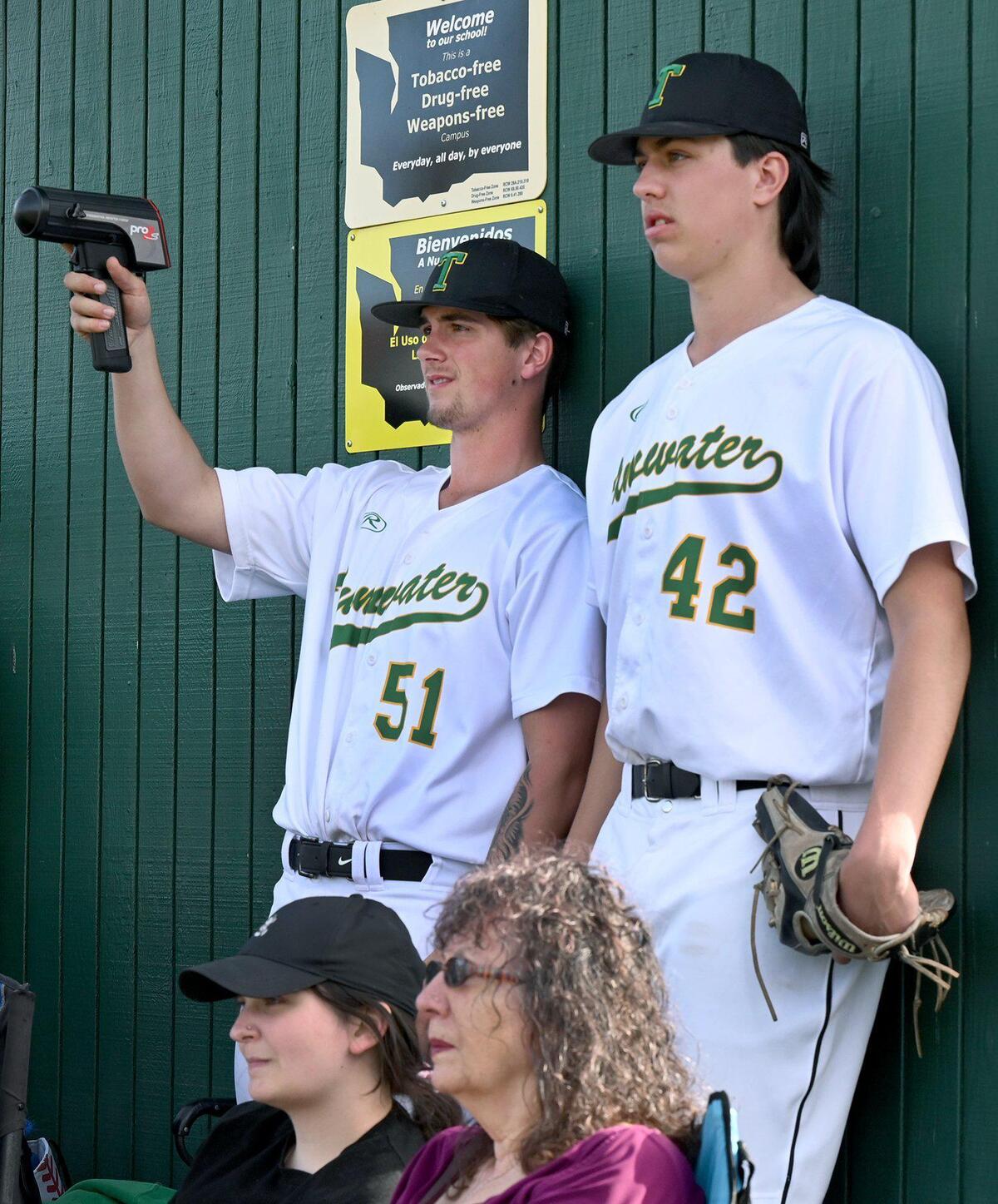 Holding a radar gun Tumwater’s Blake Smith captures the speed of teammate Ryan Orr’s pitch as fellow pitcher Jordan Hanson look on during the T-Birds game against the visiting Aberdeen Bobcats in a 2A Evergreen league contest on Thursday, April 7.