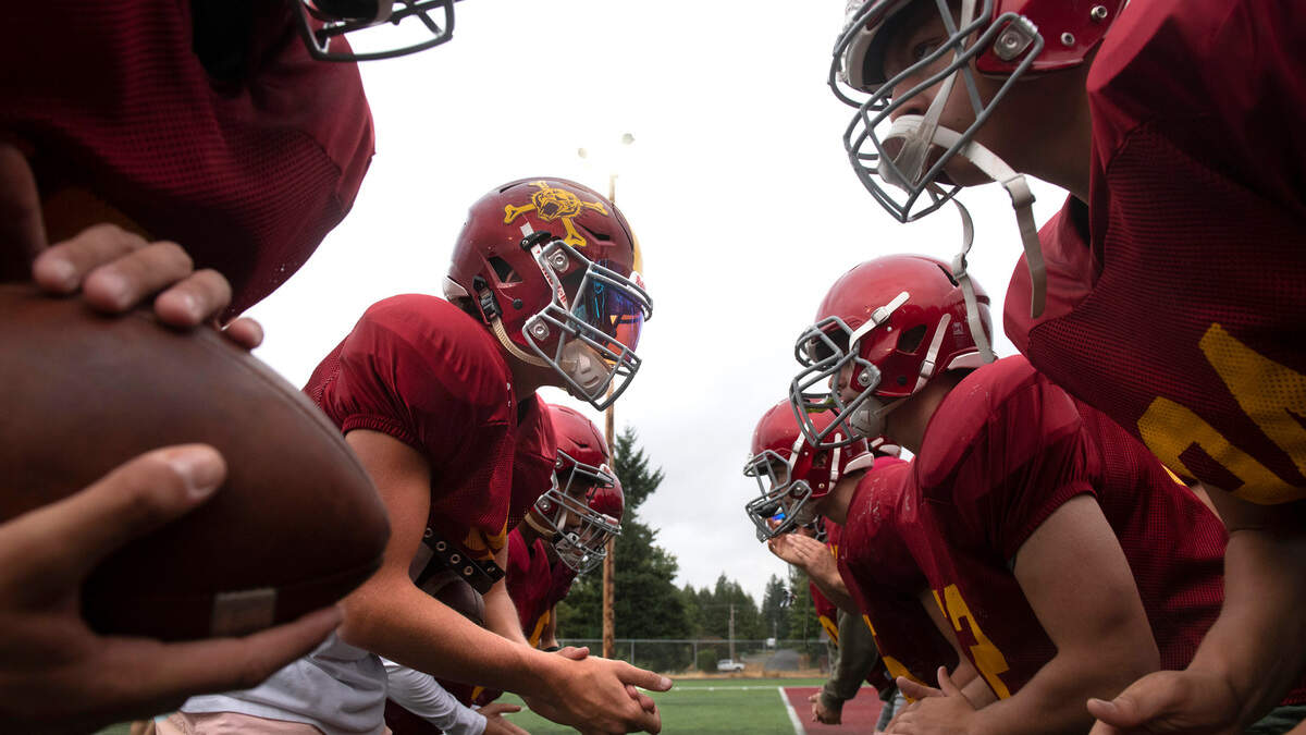 Enumclaw quarterback Malcom Harper (left) and the Hornets run through drills during football practice at Enumclaw Stadium in Enumclaw, Washington, on Thursday, Aug. 25, 2021.