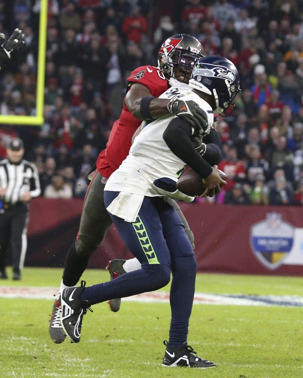 Seattle Seahawks quarterback Geno Smith is sacked by Tampa Bay Buccaneers’ Devin White during the first half of an NFL football game, Sunday, Nov. 13, 2022, in Munich, Germany. (AP Photo/Gary McCullough)