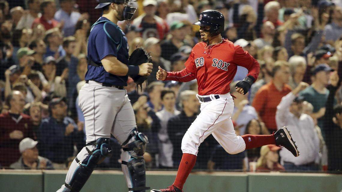Boston Red Sox's Mookie Betts crosses the plate past Seattle Mariners catcher Mike Zunino as he scores on a single by J.D. Martinez in the seventh inning of a baseball game at Fenway Park, Friday, June 22, 2018, in Boston. (AP Photo/Elise Amendola)