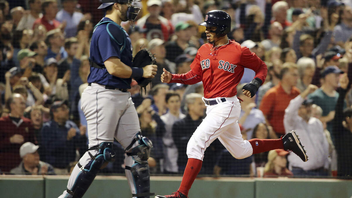 Boston Red Sox's Mookie Betts crosses the plate past Seattle Mariners catcher Mike Zunino as he scores on a single by J.D. Martinez in the seventh inning of a baseball game at Fenway Park, Friday, June 22, 2018, in Boston. (AP Photo/Elise Amendola)