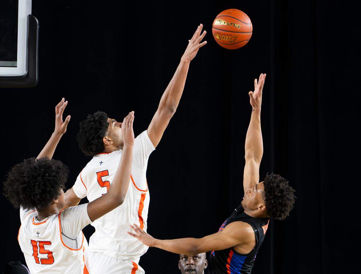 Eastside Catholic’s Jacob Cofie (5) gets a hand up to block a shot from Rainier Beach’s Darius Wilcher (12) during the Class 3A state championship game at the Tacoma Dome, on Saturday, March 2, 2024, in Tacoma, Wash.