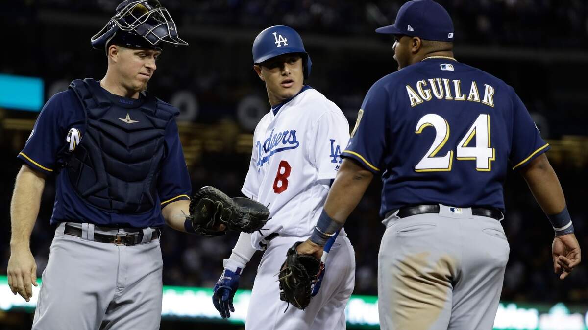 Milwaukee Brewers’ Jesus Aguilar and Los Angeles Dodgers’ Manny Machado have words during the 10th inning of Game 4 of the National League Championship Series baseball game Tuesday, Oct. 16, 2018, in Los Angeles. (AP Photo/Matt Slocum)