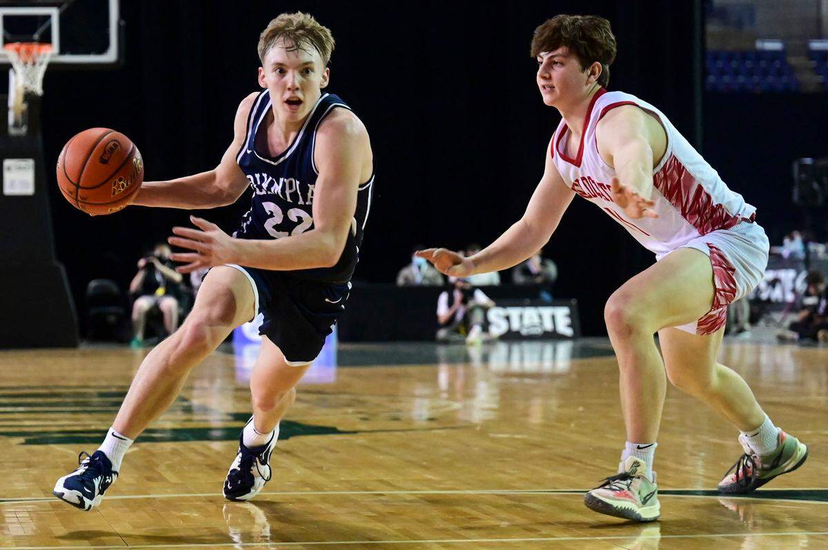 Olympia guard Parker Gerrits (22) drives past Mount Si guard Eli Spence (11) on his way into the lane during the fourth quarter of a Class 4A semifinal state tournament game on Friday, March 4, 2022, at the Tacoma Dome, in Tacoma, Wash.