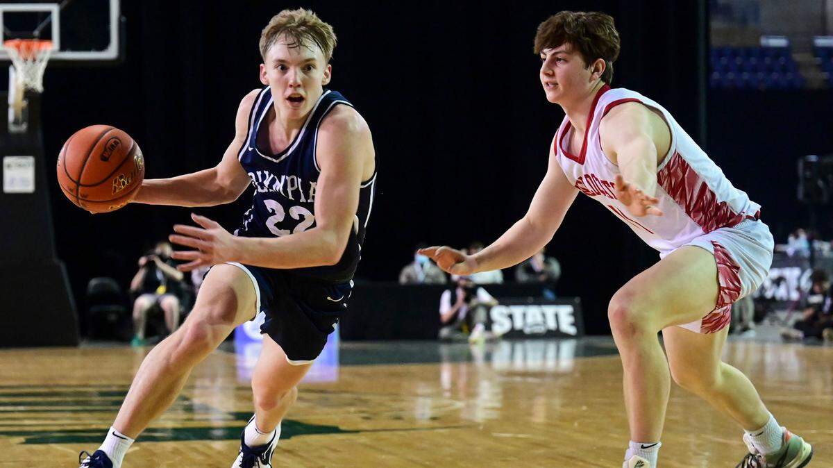 Olympia guard Parker Gerrits (22) drives past Mount Si guard Eli Spence (11) on his way into the lane during the fourth quarter of a Class 4A semifinal state tournament game on Friday, March 4, 2022, at the Tacoma Dome, in Tacoma, Wash.