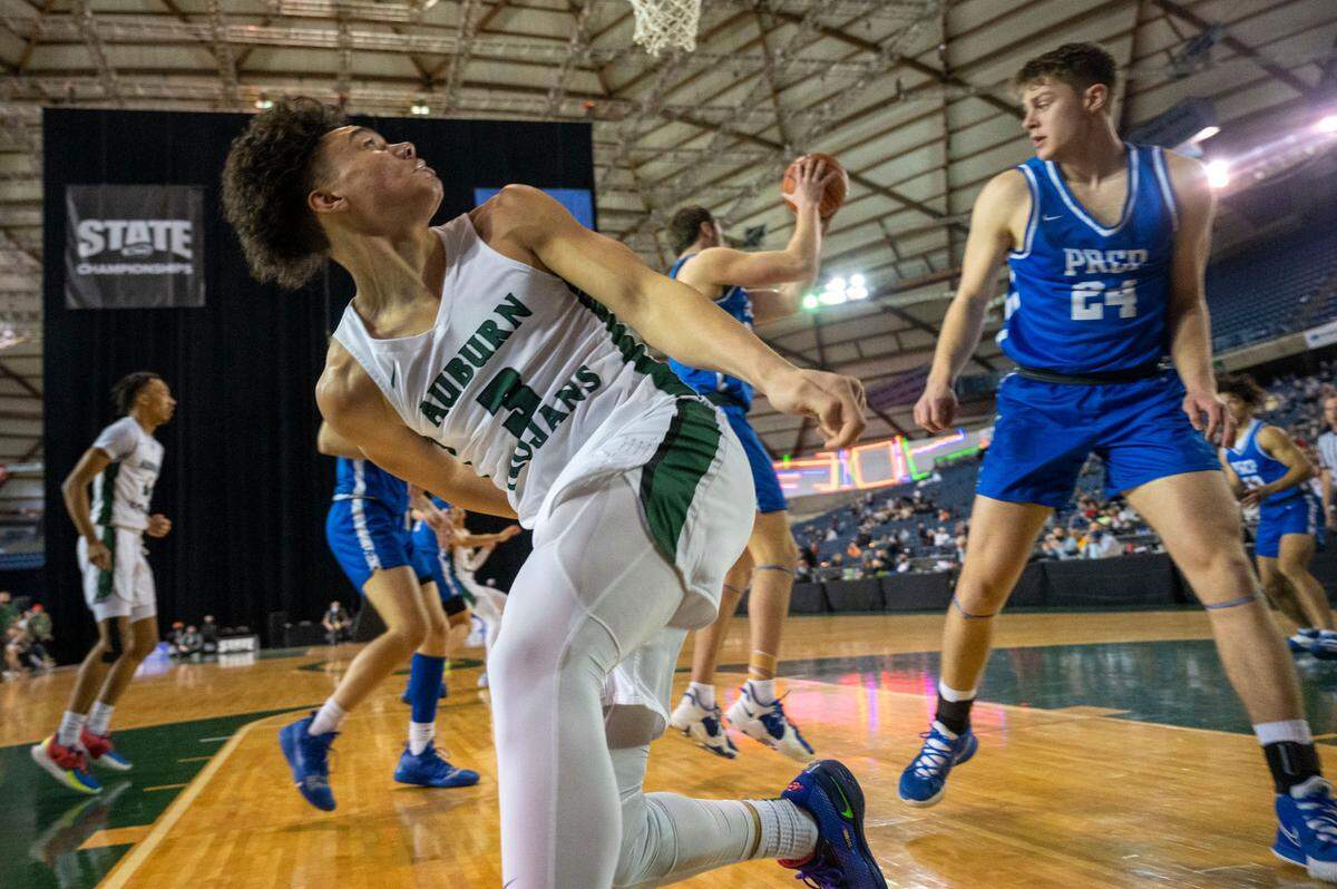 Auburn guard Maleek Arington (3) looks over his shoulder as Seattle Prep forward Jack Velling (34) grabs Arington’s missed shot during the first quarter of a Class 3A semifinal state tournament game on Friday, March 4, 2022, at the Tacoma Dome, in Tacoma, Wash.