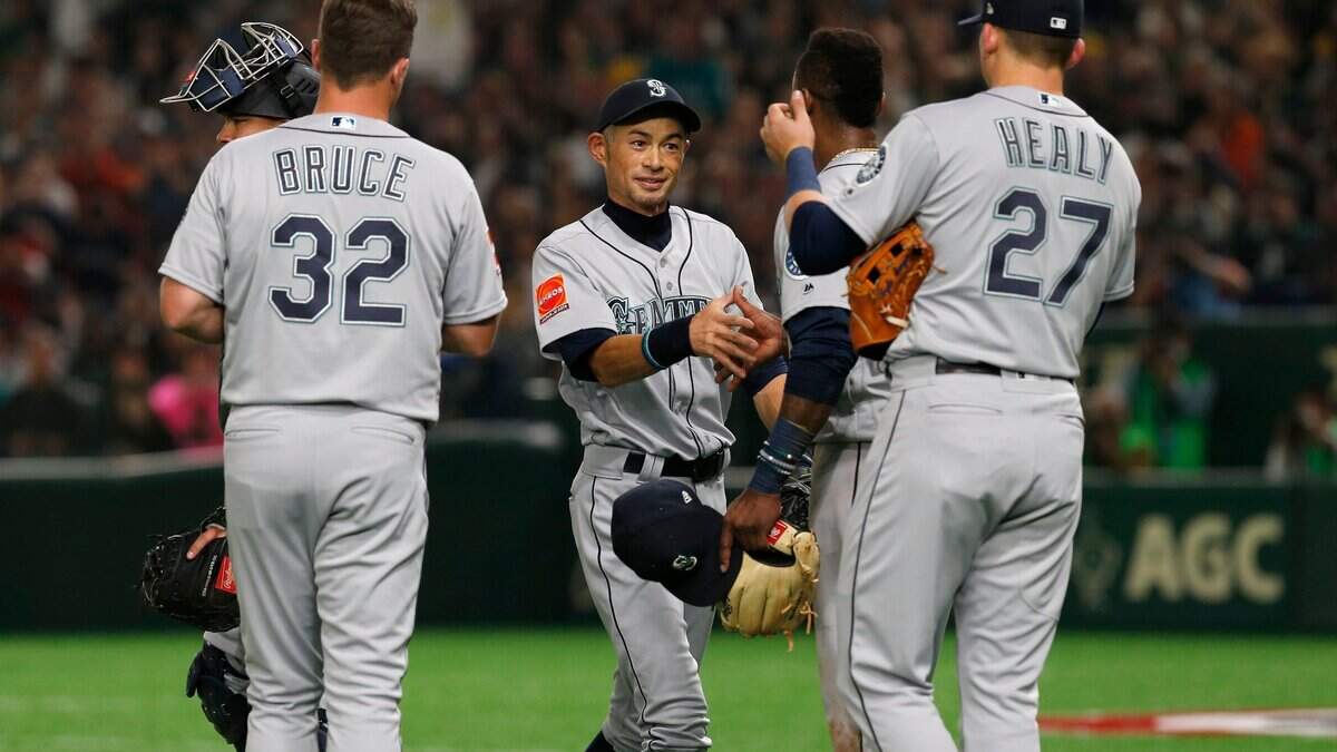 Seattle Mariners right fielder Ichiro Suzuki, center, talks to his teammates while leaving the field for defense substitution in the fourth inning of Game 1 of the Major League opening baseball series against the Oakland Athletics at Tokyo Dome in Tokyo, Wednesday, March 20, 2019. (AP Photo/Toru Takahashi)