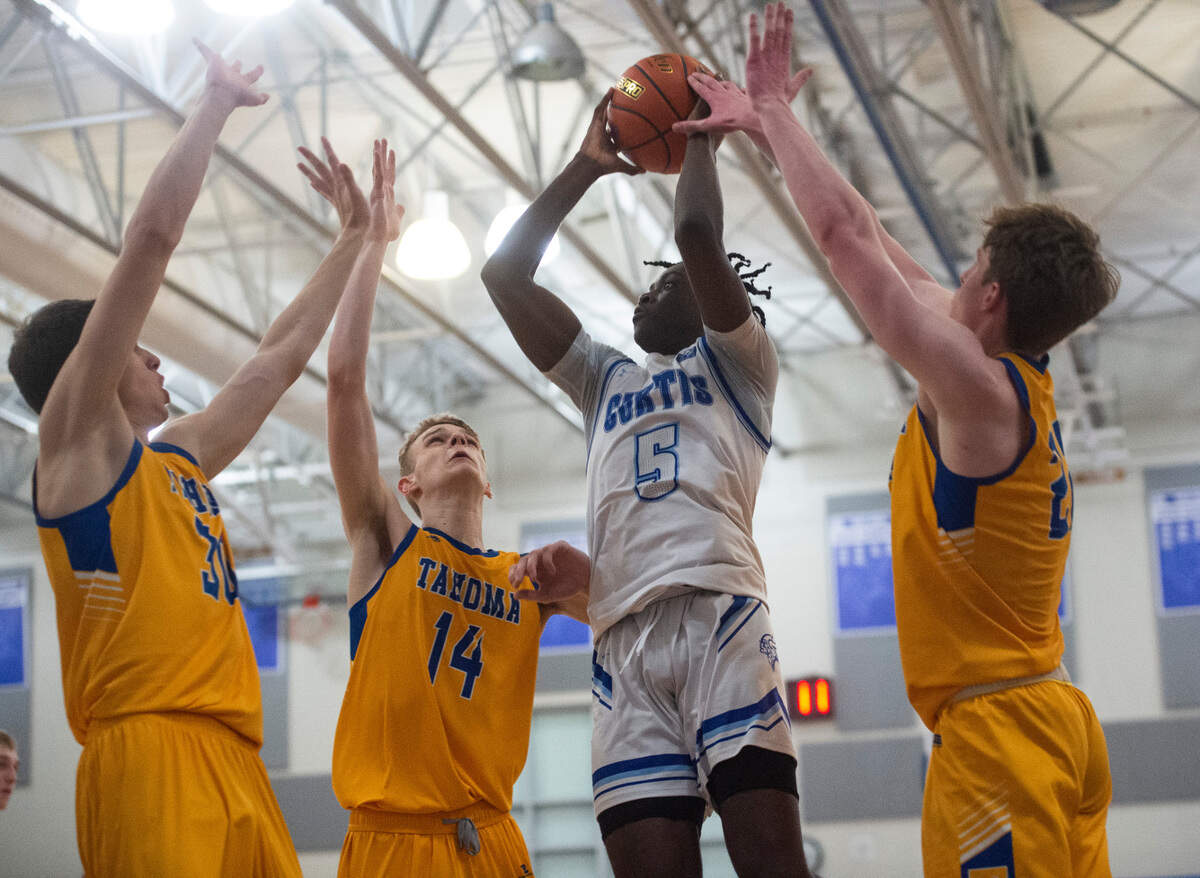 Curtis’s guard Zoom Diallo (5) jump to shoot the ball as Tahoma’s forward Adam Davis (14), forward Cooper Church (22) and forward Carson Talbert (30) defend during the 4A District 3/4 high school boys basketball championship game at the Curtis High School on Saturday, Feb. 19, 2022, in University Place, Wash.