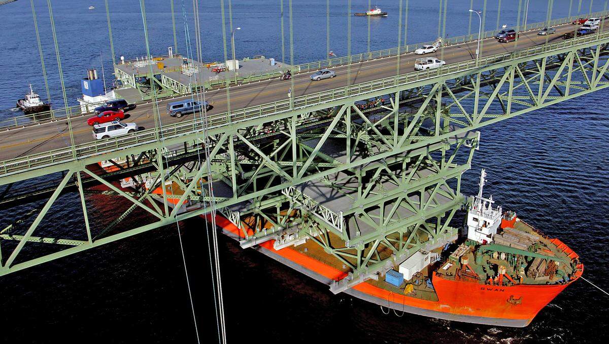 The Swan, the ship carrying the bridge deck sections for the new Tacoma Narrows Bridge, stops after temporary scaffolding on top of one of the deck sections hit the existing bridge in 2006.
