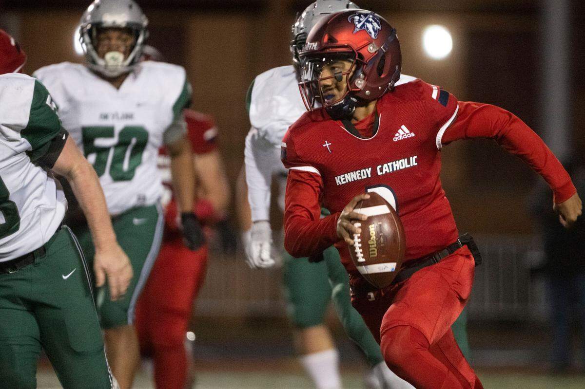 Kennedy Catholic quarterback Devon Forehand scrambles away from Skyline defenders during the first quarter of a Class 4A state quarterfinal game on Friday, Nov. 18, 2022, at Highline Memorial Stadium in Burien, Wash.