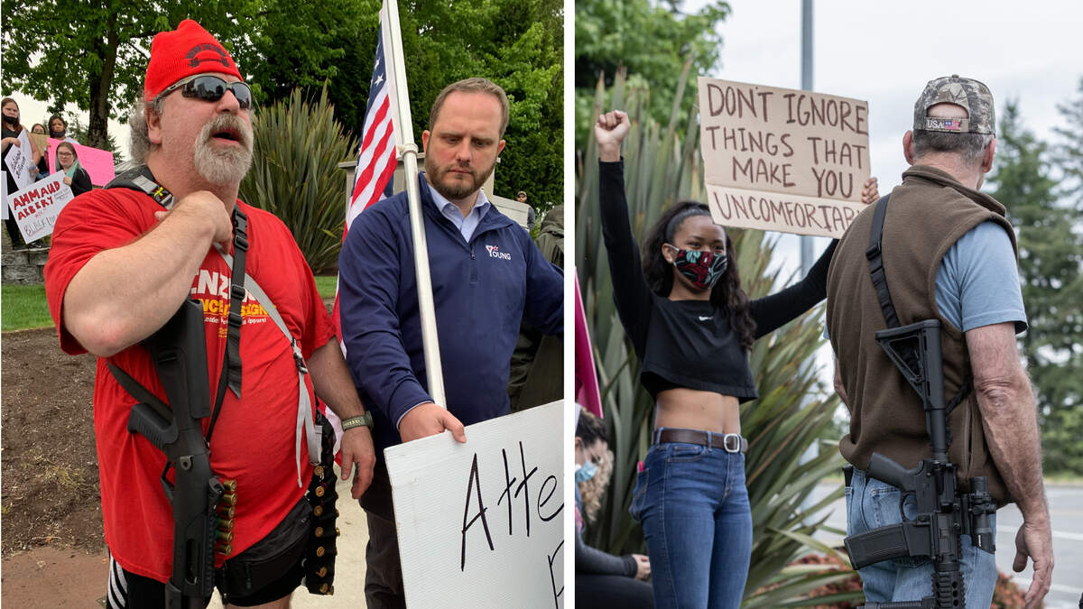 A man with a shotgun stands next to state Rep. Jesse Young, with flag, during a BLM demonstration in Gig Harbor on June 3. At right, a man wearing an AR-15-style rifle with a high-capacity magazine passes a young demonstrator.