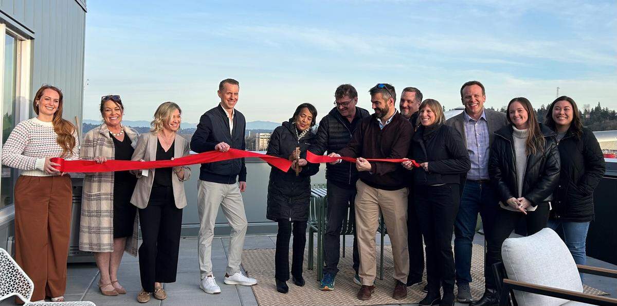 Attendees at Wednesday’s ribbon cutting included Mayor Victoria Woodards (center), Tacoma City Council member Sarah Rumbaugh (fourth from right) and Great Expectations founder Ben Maritz (sixth from right).