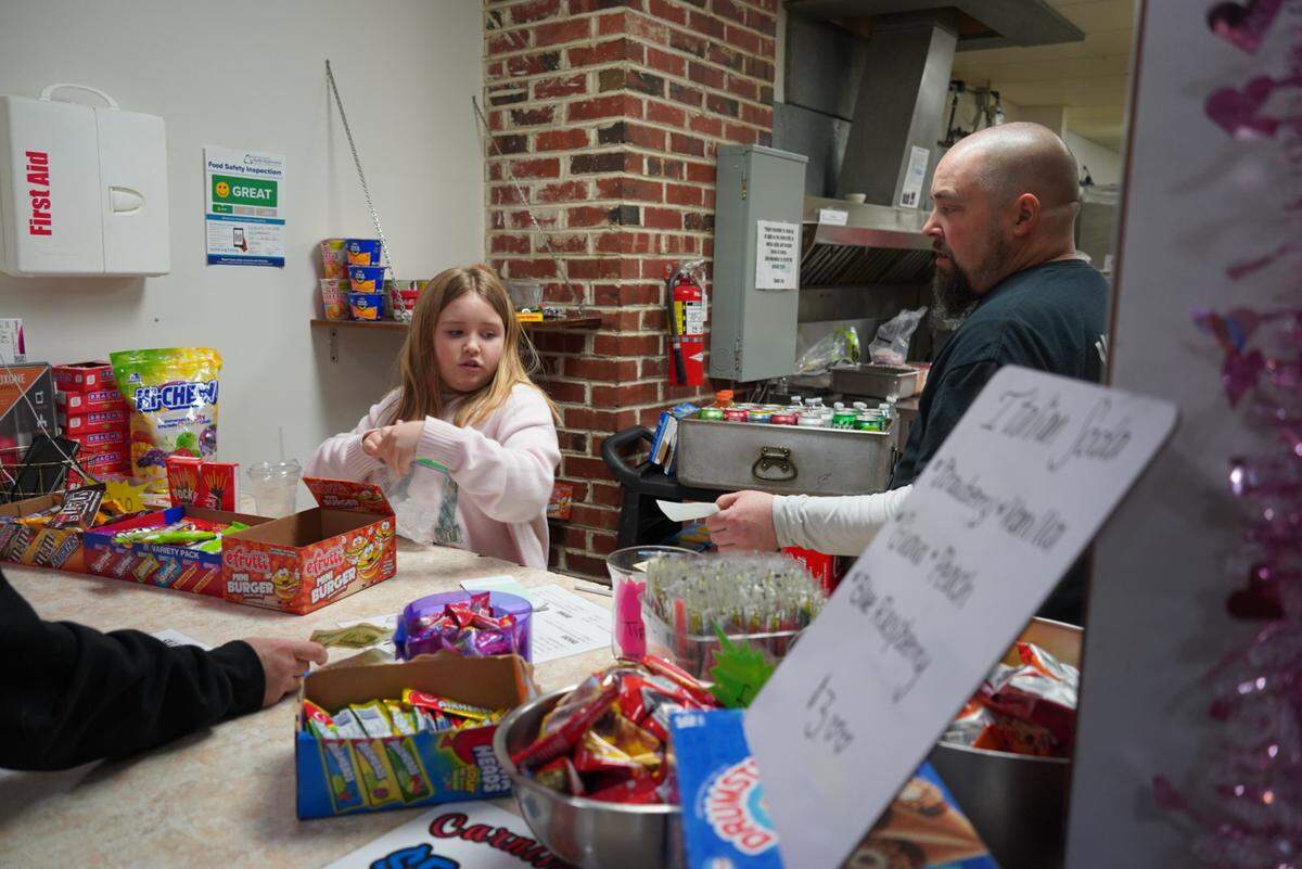 Volunteer Allie Davis takes orders with her dad, Justin Davis, during Skate Night in Vaughn, Wash., Friday, Feb. 13, 2026. They’ve been volunteering at Skate Night for three years.