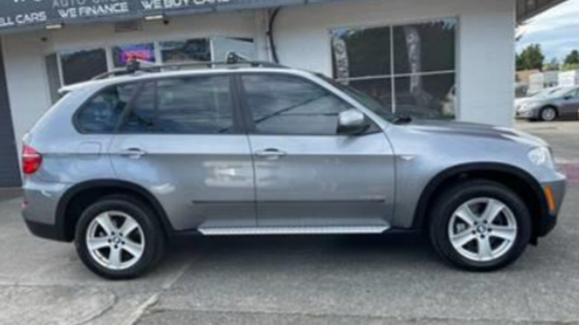 A silver 2012 BMW X5 is shown outside a car dealership. A couple is accused of stealing the vehicle during a test drive on Sept. 13, 2021, in Auburn, Washington.