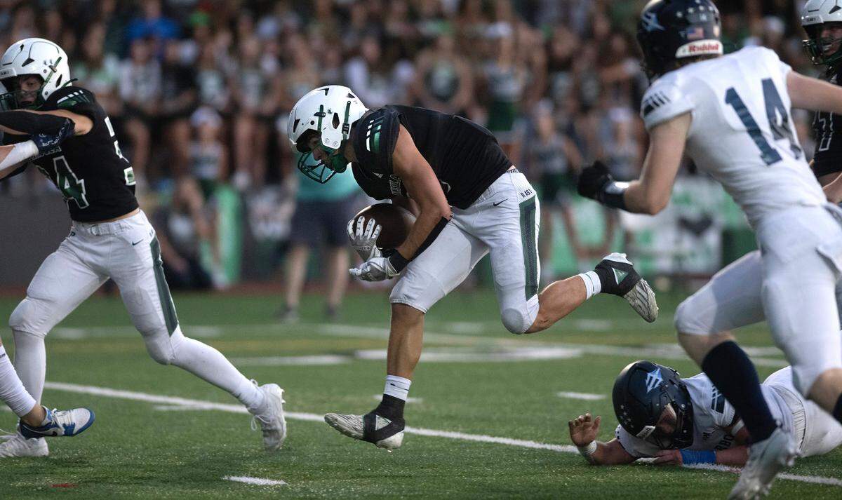 Peninsula running back Burton Conner leaps through the Gig Harbor defense for a touchdown run during the first half of Friday night’s Fish Bowl crosstown rivalry football game at Roy Anderson Field in Purdy, Washington, on Sept. 15, 2023. Gig Harbor won the game, 21-20.