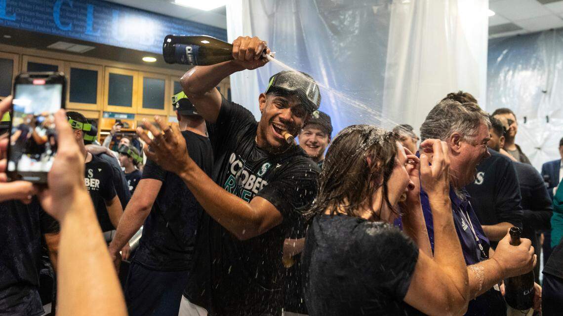 Seattle Mariners’ Julio Rodriguez and teammates celebrates in the clubhouse after a baseball game against the Oakland Athletics, Friday, Sept. 30, 2022, in Seattle. The Mariners won 2-1 to clinch a spot in the playoffs. (AP Photo/Stephen Brashear)