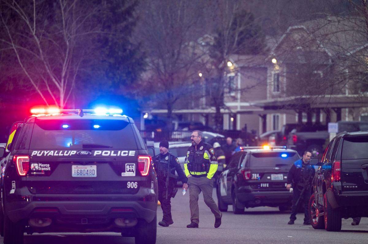 Law enforcement officers from various local agencies manage the scene of a stand-off where a Puyallup Police officer was shot by gunfire on Tuesday, Jan. 24, 2023, in Puyallup, Wash. According to Sgt. Darren Moss, from the Pierce County Sheriff’s Department, the officer who was shot only had minor injuries and was being treated at a local hospital.