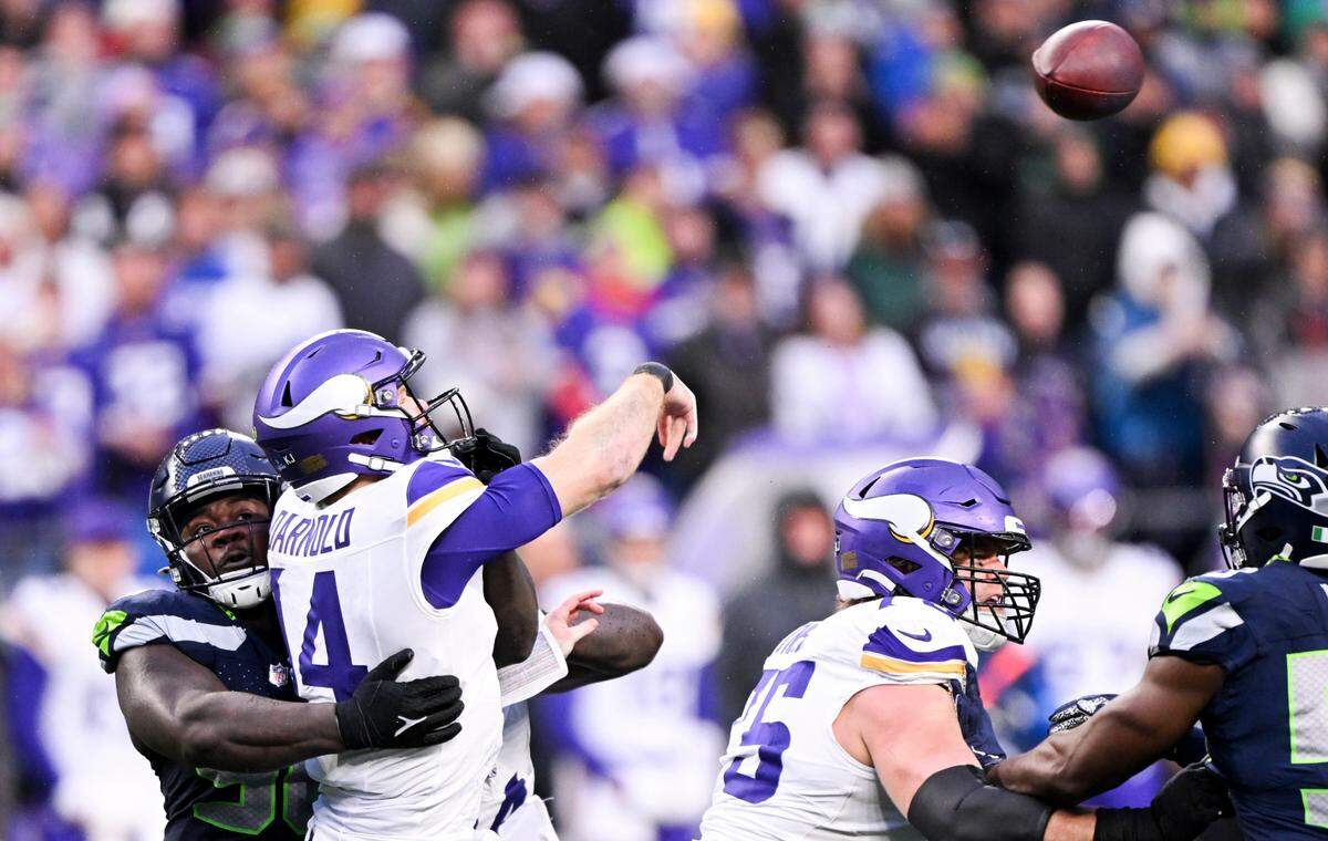 Minnesota Vikings quarterback Sam Darnold (14) throws an incompletion under pressure from Seattle Seahawks defensive tackle Jarran Reed (90) during the fourth quarter of the game at Lumen Field, on Sunday, Dec. 22, 2024, in Seattle, Wash.