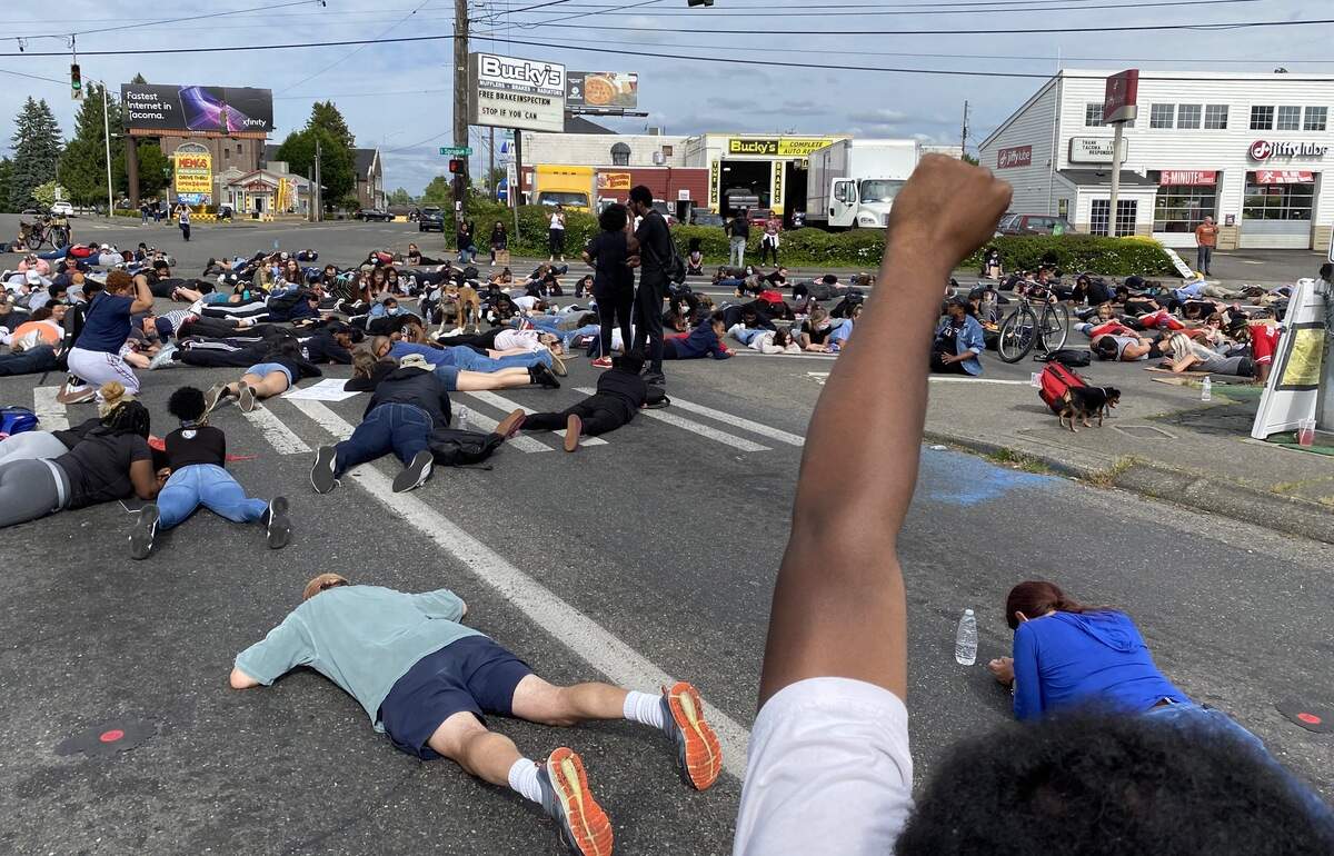 Protesters stage a “die in” Wednesday at the intersection of Sprague and Division avenues. They were protesting the deaths of national and local men and women who have died at the hands of police.