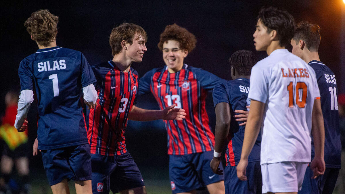 Silas players celebrate after a goal by teammate Charles Ganu as Lakes’ Christjan Mago (10) looks on during the second half of a Pierce County League game on Thursday, March 31, 2022, at Silas High School in Tacoma, Wash.