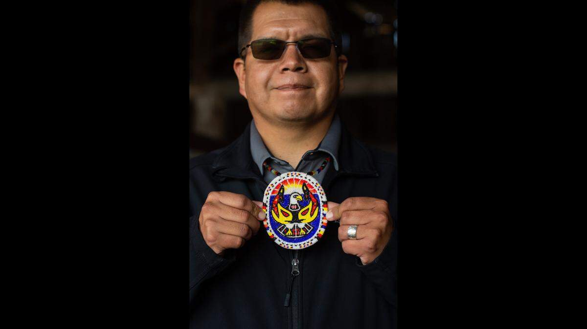Lummi Nation Chairman Lawrence Solomon holds a beaded medallion featuring the Tribe’s logo, an eagle with two orcas, at the Tribe’s canoe shed on the Stommish grounds on Friday, Oct. 1. Solomon’s wife Denise, co-leader of the Blackhawk Singers group, had the medallion made for him when he became chairman two years ago.