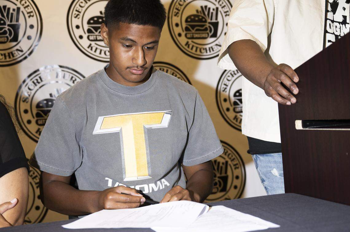 Lincoln quarterback Sione Kaho signs a NIL deal with Secret Burger Kitchen, on Wednesday, Aug. 13, 2025, in Tacoma, Wash.