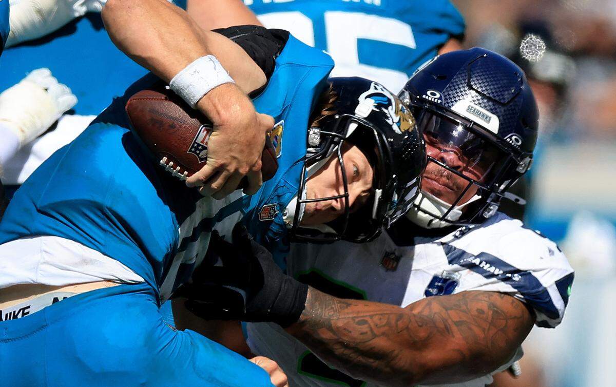 JACKSONVILLE, FLORIDA - OCTOBER 12: Trevor Lawrence #16 of the Jacksonville Jaguars is sacked by Byron Murphy II #91 of the Seattle Seahawks during the third quarter in the game at EverBank Stadium on October 12, 2025 in Jacksonville, Florida. (Photo by Mike Carlson/Getty Images)