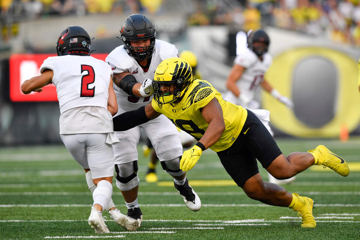 Eastern Washington quarterback Gunner Talkington (2) tries to elude the tackle of Oregon linebacker Mase Funa (18) as Eastern Washington offensive lineman Wyatt Hansen (61) blocks during the second quarter of an NCAA college football game Saturday, Sept. 10, 2022, in Eugene, Ore. (AP Photo/Andy Nelson)