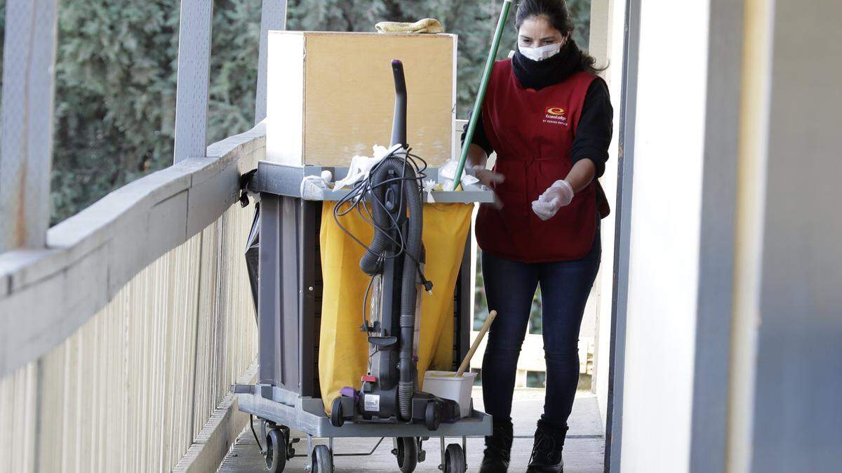 A housekeeping worker wears a mask as she cleans a room, Wednesday, March 4, 2020, at an Econo Lodge motel in Kent, Wash. King County Executive Dow Constantine said that the county had purchased the 85-bed motel south of Seattle to hold confirmed COVID-19 patients and those who have been exposed.
