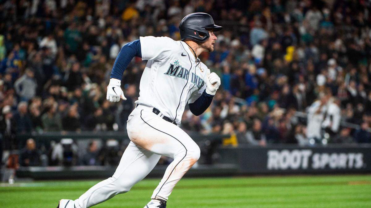 Seattle Mariners left fielder Jarred Kelenic (10) runs to first base after hitting the ball during the seventh inning of the Mariners home opener against the Cleveland Guardians at T-Mobile Park in Seattle on Thursday, March 30, 2023.