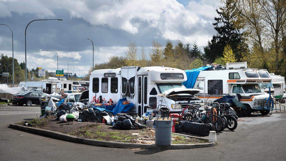 Motorhome and travel trailers have set up an encampment in the Center Street park-and-ride lot bordering state Route 16 in Tacoma on Wednesday, April 19, 2023.