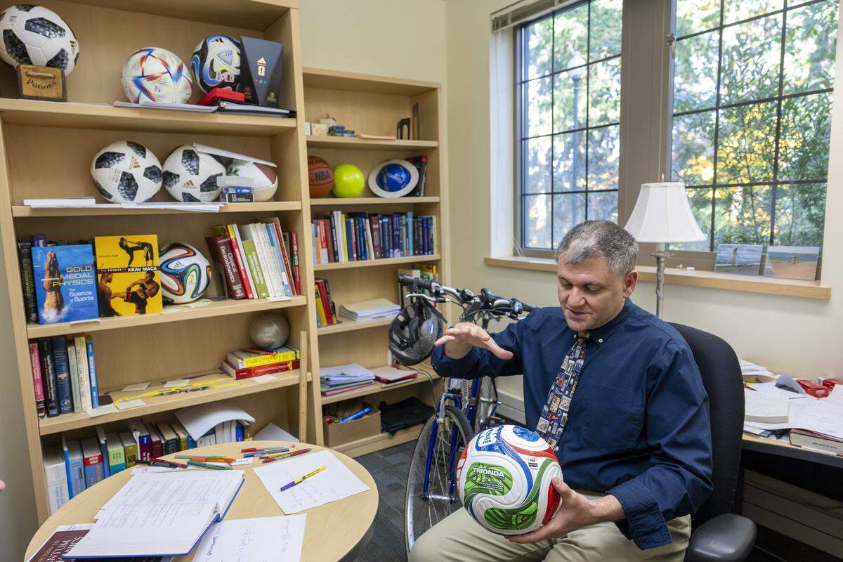 Professor John Eric Goff talks through the studies done on the aerodynamics of FIFA World Cup balls in his office on Wednesday, Oct. 29, 2025, at the University of Puget Sound in Tacoma, Wash. Previous World Cup balls involved in his research sit on shelves nearby.