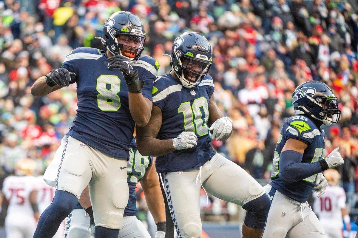 Seattle Seahawks defensive end Carlos Dunlap (8) and outside linebacker Benson Mayowa (10) celebrate after Dunlap sacked San Francisco 49ers quarterback Jimmy Garoppolo (10) for a safety in the third quarter of an NFL game on Sunday at Lumen Field in Seattle.