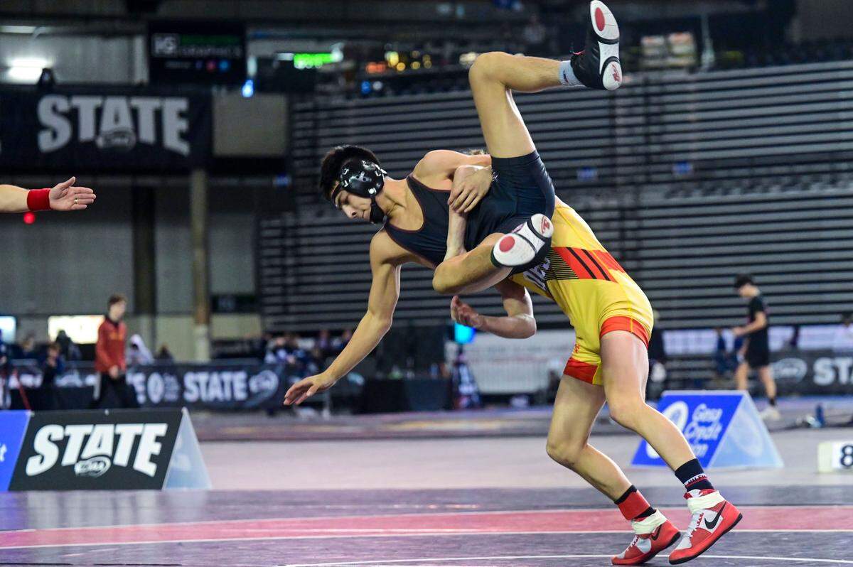 Orting’s Bryan Dickerson tosses Grandview’s Evan Benitez in the 126-pound 2A championship match at Mat Classic XXXIII on Saturday, Feb. 19, 2022, at the Tacoma Dome in Tacoma, Wash.
