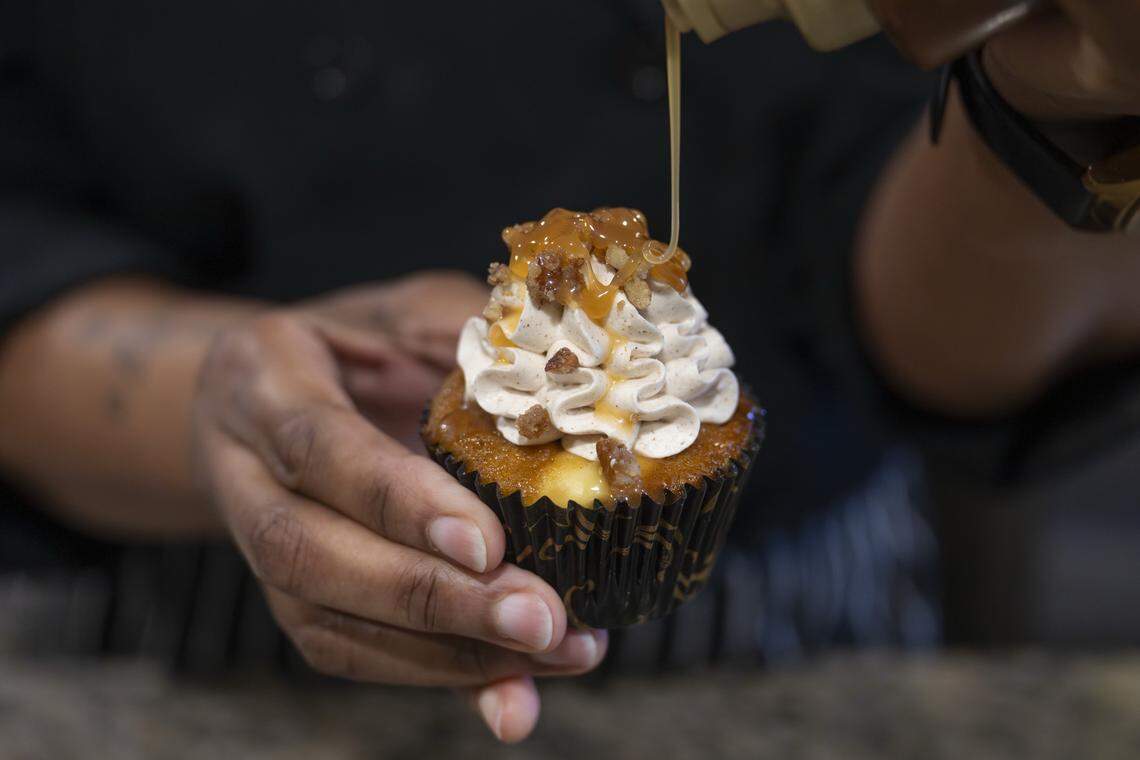 Caramel is drizzled over the top of a Kingdom cupcake by Regina Eudora Gray on Friday, Feb. 20, 2026, at Eudora's Bakery & Cafe in Tacoma, Wash.
